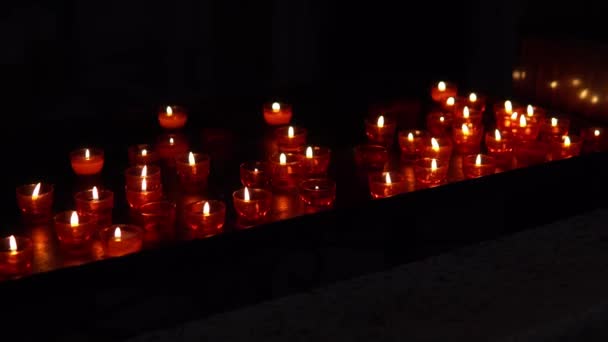 Κόκκινα κεριά στο σκοτάδι στην εκκλησία στην Ευρώπη — Αρχείο Βίντεο