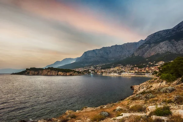 Makarska, Croatia. View of the beach and the old town at sunset — Stock Photo, Image