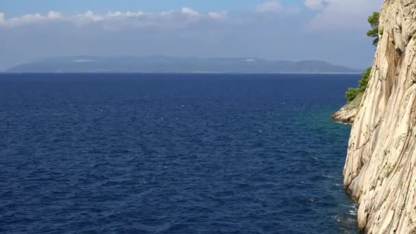 Zee golven en rotsen op een zomerdag. Adriatische Zee. Makarska. Kroatië — Stockvideo