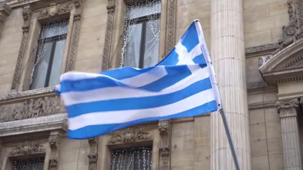 Greek flag waving on the strong wind on the background of buildings — Stock Video