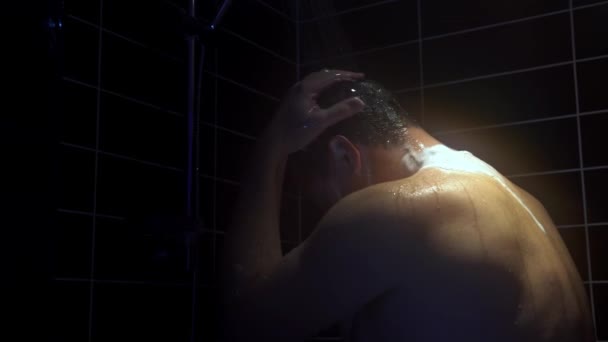 Jeune homme se lave la tête sous la douche — Video