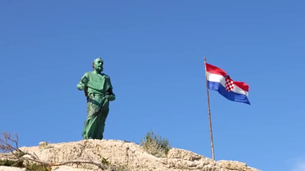 Makarska, Croatia. statue of St. Peter with a key symbol in his hands and the Croatian national flag — Stock Video