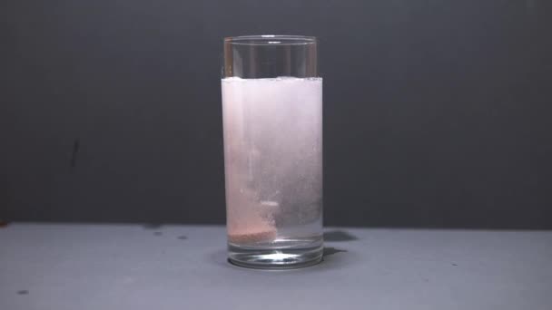 Effervescent tablet falls to the bottom of the glass slow motion — Stock Video