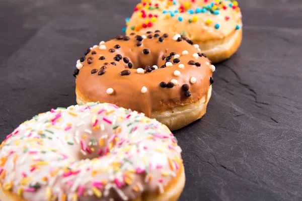 Donuts Berliner com esmalte sobre um fundo preto — Fotografia de Stock