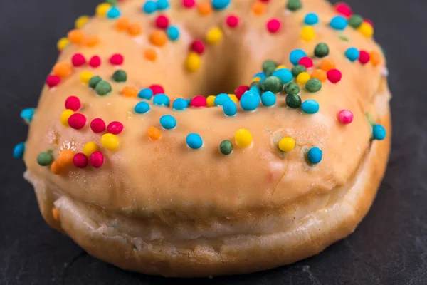 Donut fresco com coberturas em um fundo escuro — Fotografia de Stock