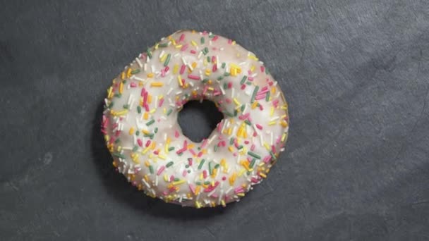 Zoete donut roteert op een donkere achtergrond. Traditionele Amerikaanse zoetheid — Stockvideo