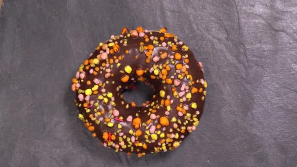 Сладкий пончик вращается на тёмном фоне. Традиционная американская сладость — стоковое видео