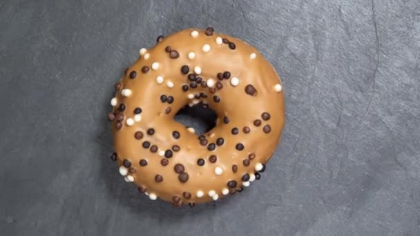 Doce donut gira sobre um fundo escuro. Doçura americana tradicional — Vídeo de Stock