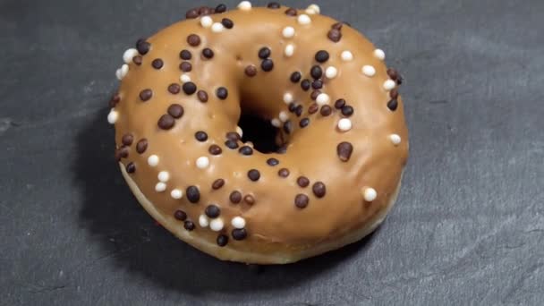 Doce donut gira sobre um fundo escuro. Doçura americana tradicional — Vídeo de Stock