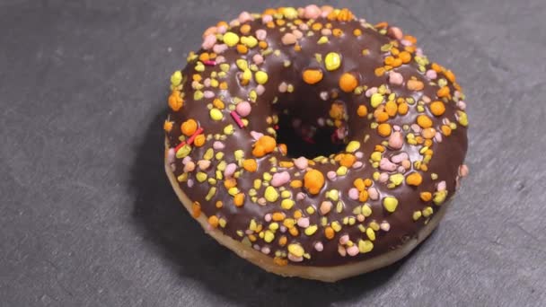 甘いドーナツは、暗い背景に回転します。伝統的なアメリカの甘さ — ストック動画