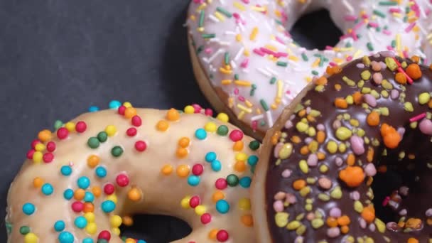 Γλυκό donuts γυρίζοντας σε σκούρο φόντο. Παραδοσιακά αμερικανική γλυκύτητα — Αρχείο Βίντεο