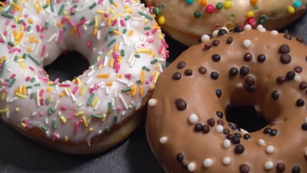 Γλυκό donuts γυρίζοντας σε σκούρο φόντο. Παραδοσιακά αμερικανική γλυκύτητα — Αρχείο Βίντεο
