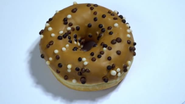 Rosquillas dulces girando sobre un fondo blanco. Dulzura tradicional americana — Vídeos de Stock