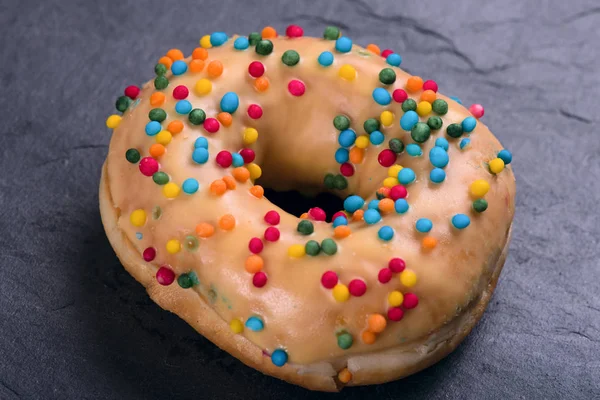 Frischer Donut mit Toppings auf dunklem Hintergrund — Stockfoto