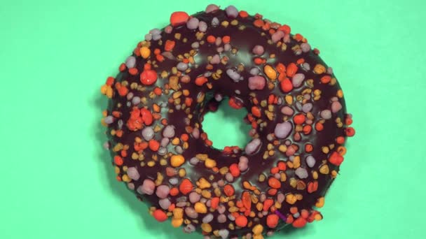 Delicioso donut doce girando em fundo colorido — Vídeo de Stock