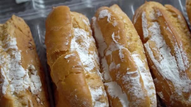 Os eclairs frescos polvilhados com o pó giram na tabela — Vídeo de Stock