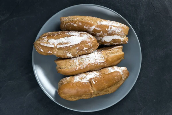 Eclairs with the filling on the plate is a traditional French dessert