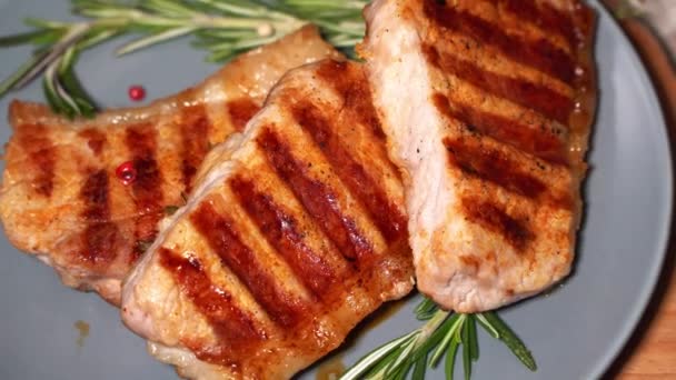 Горячее мясо. Кусочки жареной свинины вращаются на тарелке — стоковое видео