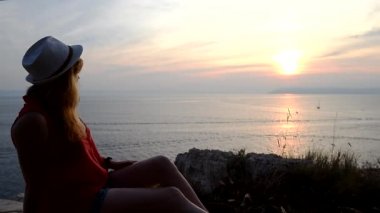 Yaşam anlamı hakkında düşünme deniz üzerinde gün batımı izlerken kız