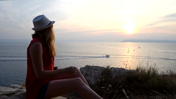 Fille regarder coucher de soleil sur la mer en pensant à la signification de la vie — Video