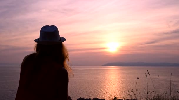Chica viendo la puesta de sol sobre el mar pensando en el significado de la vida — Vídeos de Stock