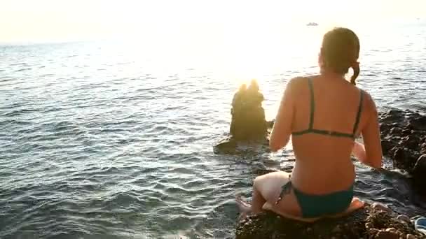 Meisje in de zonsondergang op het strand — Stockvideo