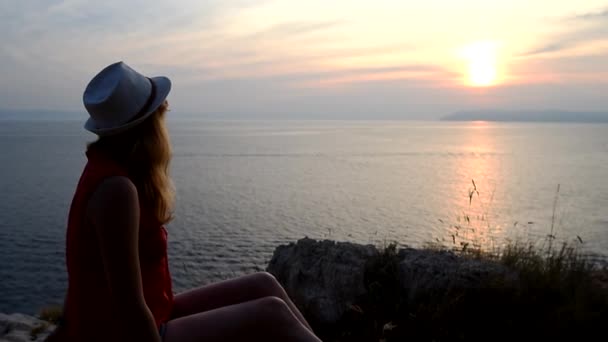 Menina assistindo por do sol sobre o mar pensando sobre o significado da vida — Vídeo de Stock