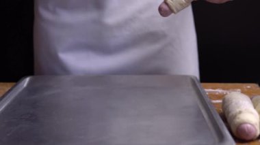 bir fırın tepsisine bazı sosis rulo koyarak