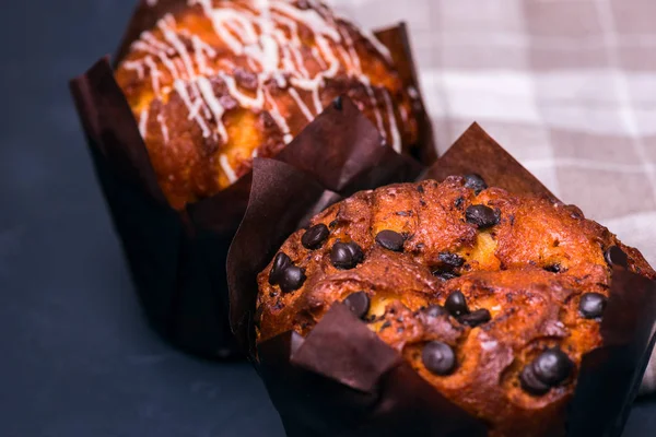 Chiudete. Chiave oscura. Muffin con pezzi di cioccolato in carta nera — Foto Stock