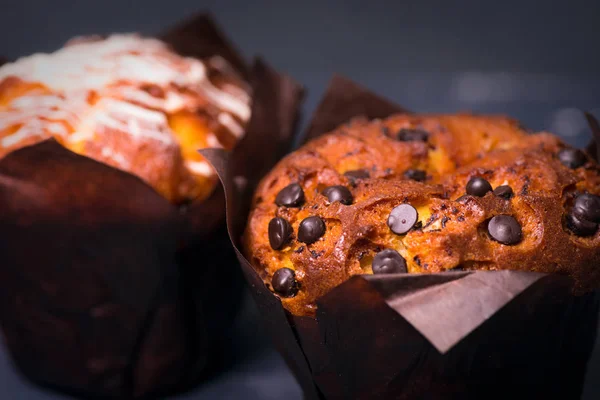 Chiudete. Chiave oscura. Muffin con pezzi di cioccolato in carta nera — Foto Stock