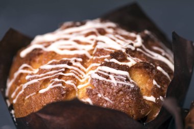 Yakından kapatın. Siyah kağıt içinde çikolata parçaları ile Muffin