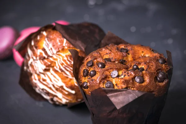 Chiudete. Chiave oscura. Muffin con pezzi di cioccolato in carta nera — Foto Stock