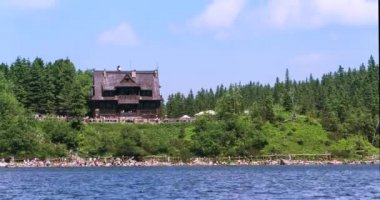 Yaz gününde turistler bir kalabalık ile Polonya Tatras dağ gölünde kulübe görünümü.