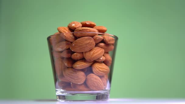 Almond berputar close-up pada latar belakang pistachio dalam cangkir — Stok Video