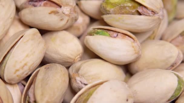 Close-up. Macro. Gebakken pistachenoten in een schelp roteren in een cirkel. Achtergrond — Stockvideo