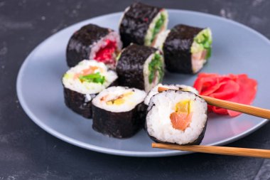 Rulo üst görünümü ile bir tabak arka plan üzerinde büyük çubuklar ile Sushi rulo
