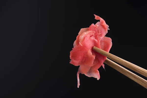 Wasabi mit Essstäbchen auf schwarzem Hintergrund — Stockfoto