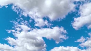 Mavi gökyüzünde hızlı çalışan beyaz bulutların zaman atlamalı görünümü