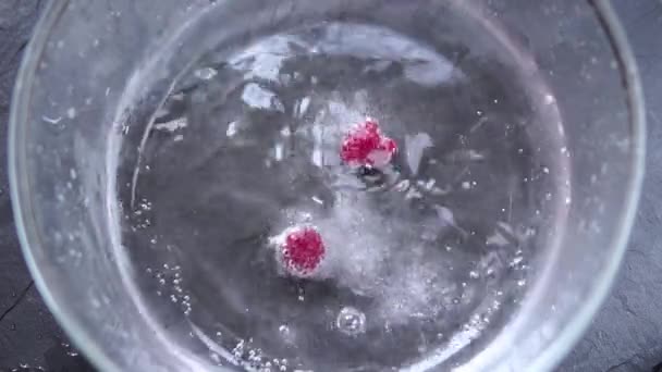 Nahaufnahme Von Himbeeren Die Mit Wasser Glasschüssel Fallen — Stockvideo