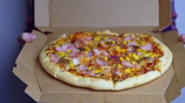 İnsan elinde pizza ile karton kutu