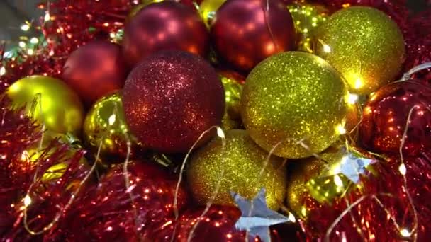 休日の背景を持つ光沢のある赤と金色のクリスマスボールの近いビュー — ストック動画