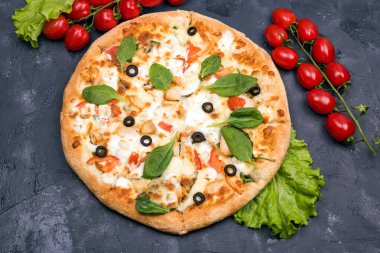 Zeytin dilimleri ve yeşil salata soslu pizza.