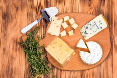 Tahta bir masaya yakın plan farklı peynirler.