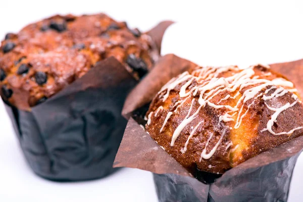 Muffin freschi con cioccolato in carta da imballaggio su sfondo bianco — Foto Stock