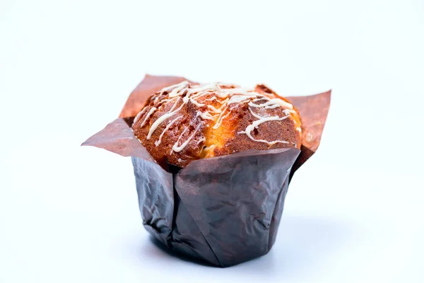 Muffin fresco con cioccolato in carta da imballaggio su sfondo bianco — Foto Stock