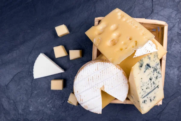 Diferentes quesos en el primer plano de la pizarra. espacio de copia — Foto de Stock