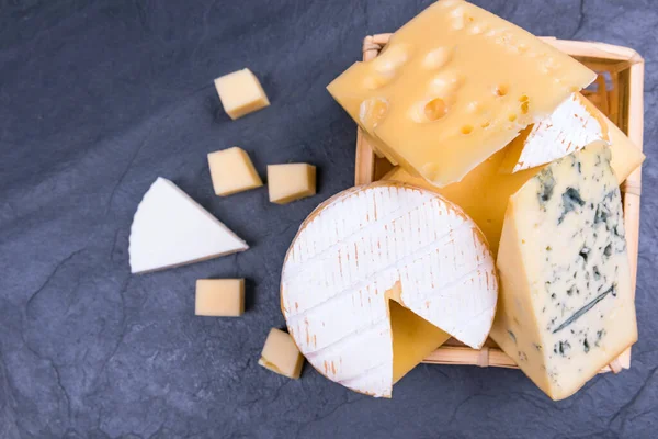Diferentes quesos en el primer plano de la pizarra. espacio de copia — Foto de Stock