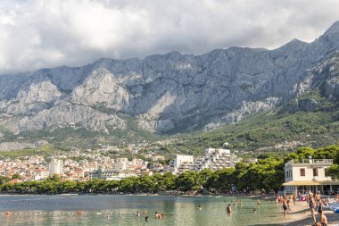Makarska Eylül 2018 Hırvatistan. Yeşil çam ağaçlı Makarska plajı manzarası