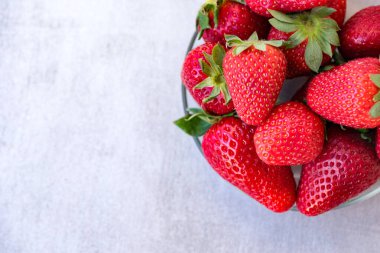 Taze çilekler masanın üstündeki kaseye kapanıyor.