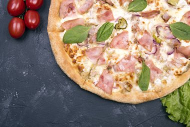 Geleneksel İtalyan pizzası ve vişneli domatesler koyu arka planda